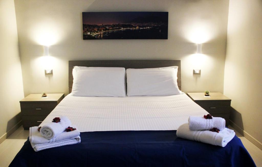 um quarto com uma cama grande e toalhas em Relais Borbonico em Nápoles