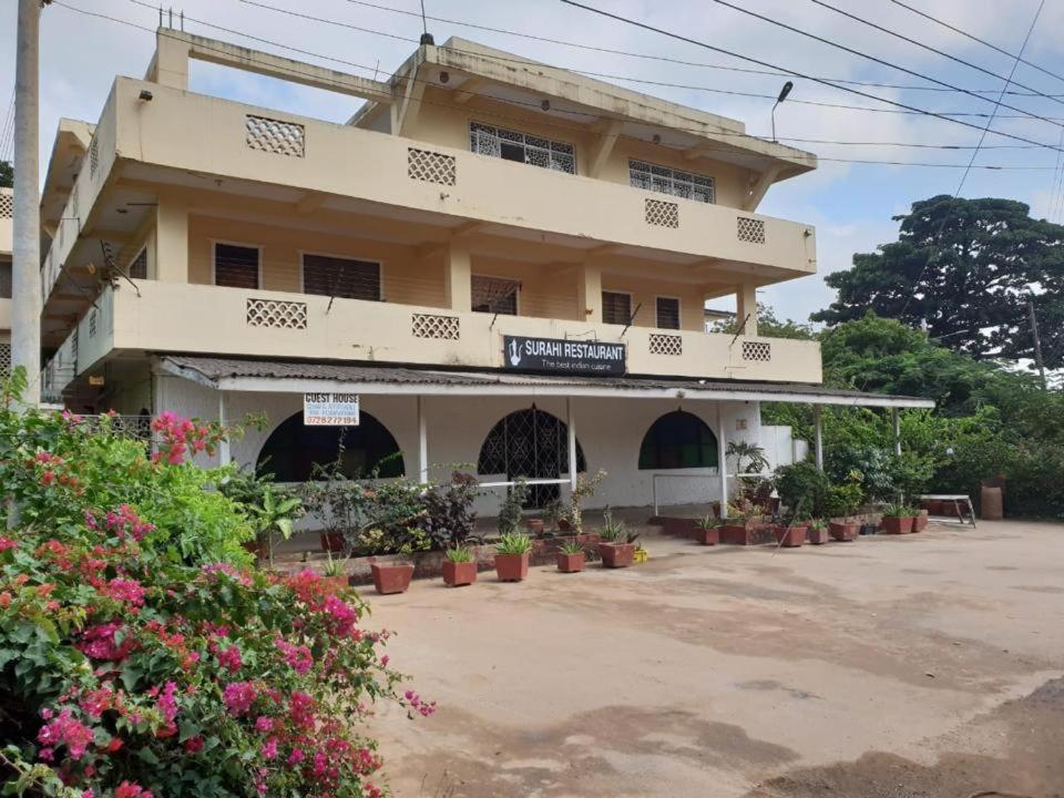 a building with potted plants in front of it at Surahi Restaurant & Guest House in Malindi