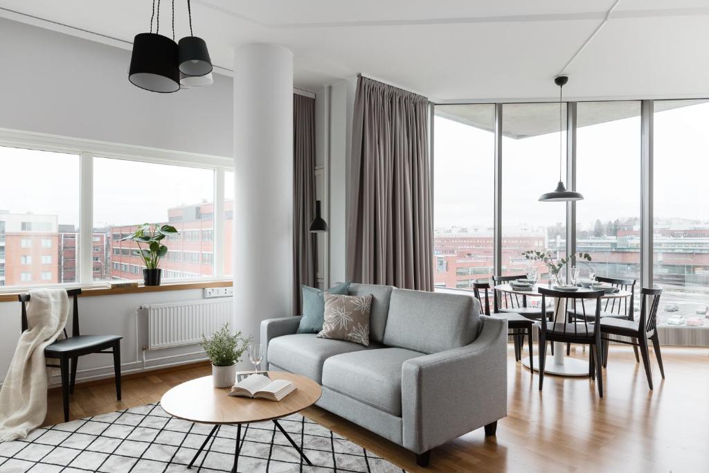 a living room with a couch and a table at SleepWell Apartments Itäkeskus, close to metro in Helsinki