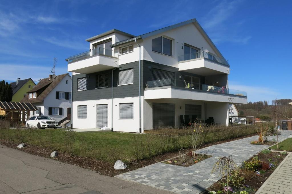 Cette grande maison blanche dispose d'un balcon. dans l'établissement Ferienwohnung Haag, à Uhldingen-Mühlhofen