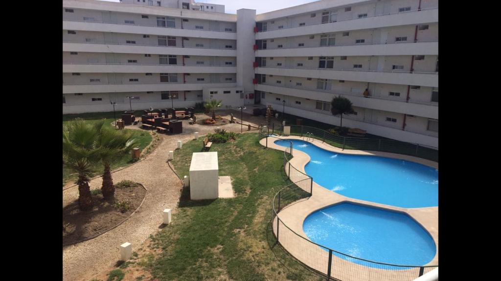 einen Blick über ein großes Gebäude mit zwei Pools in der Unterkunft Departamento en playa in La Serena