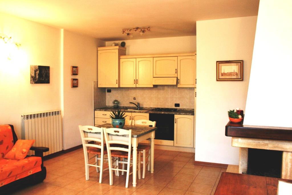 
a kitchen with a table and chairs and a refrigerator at Residence Podere Olmo in Sovicille
