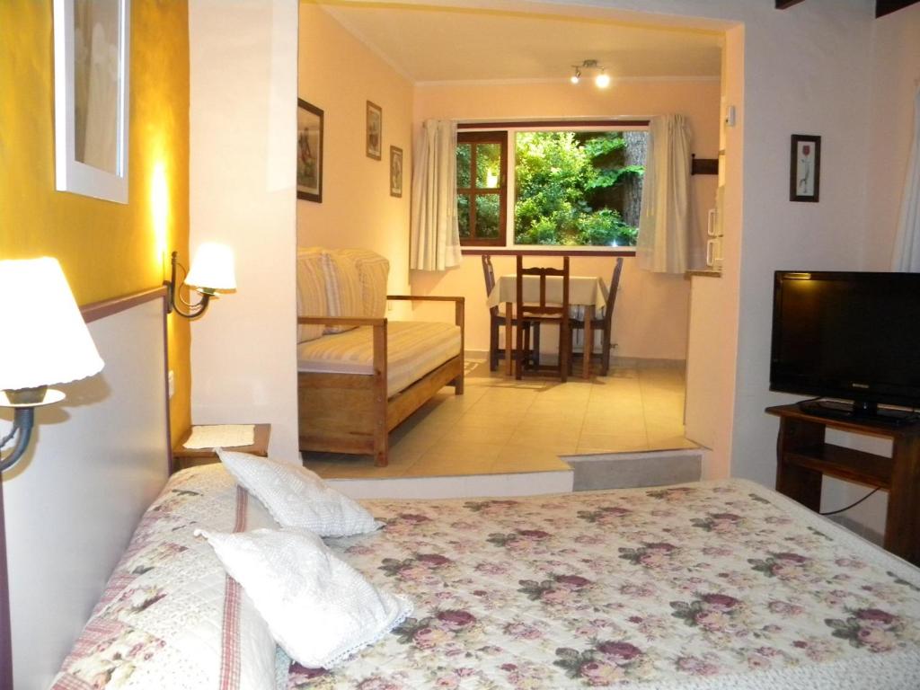 1 dormitorio con 1 cama y sala de estar en Casa los Tilos en Valeria del Mar
