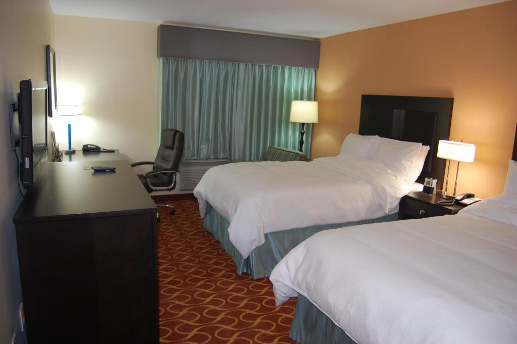a hotel room with two beds and a desk at Lux Hotel & Spa, Trademark Collection by Wyndham in Arlington