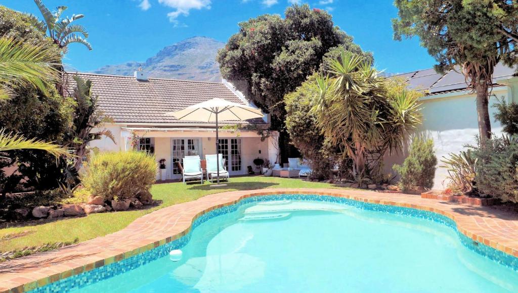a house with a swimming pool in the yard at Hout Bay Beach Cottage in Hout Bay