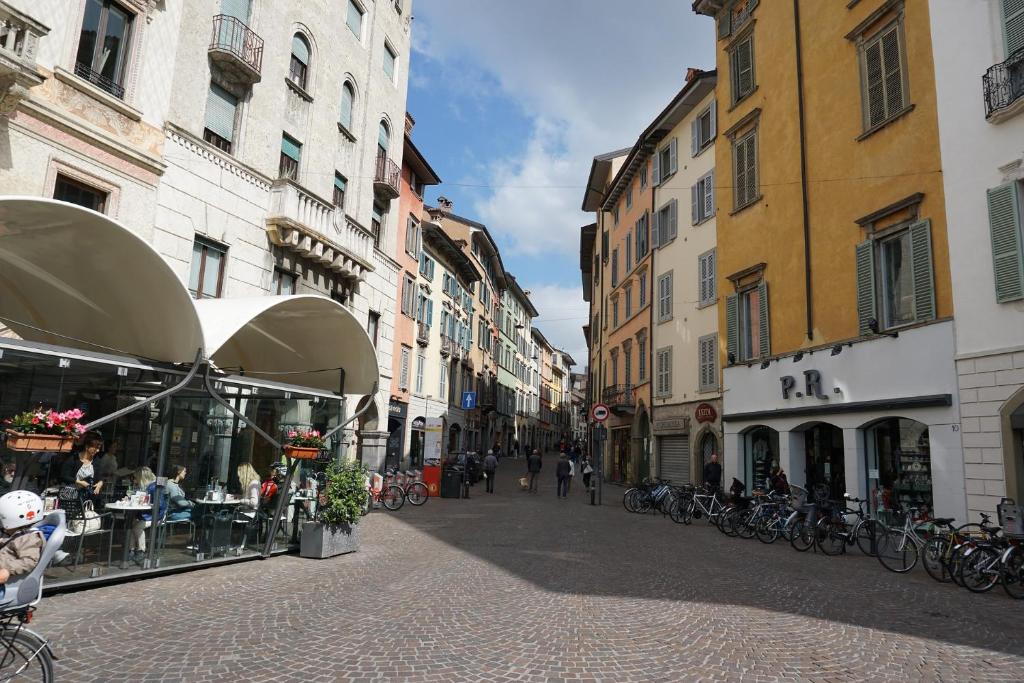 a street in a city with buildings and tables and bikes at "Your Home" Bergamo Centro in Bergamo