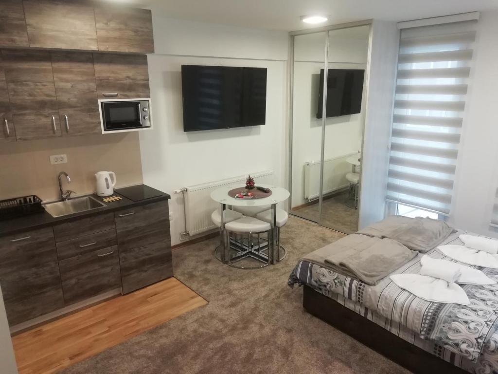 Apartman Centar 1 في أوزيتشي: غرفة نوم بسرير ومغسلة وطاولة