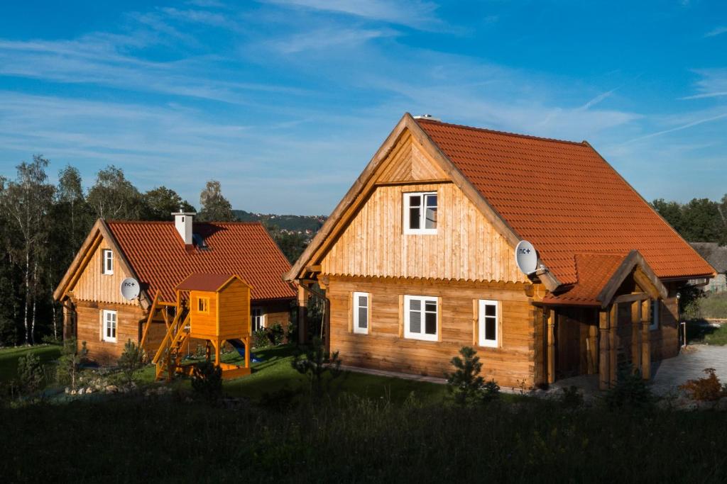 twee houten huizen met een oranje dak bij Wrzosowe Zacisze in Siepraw