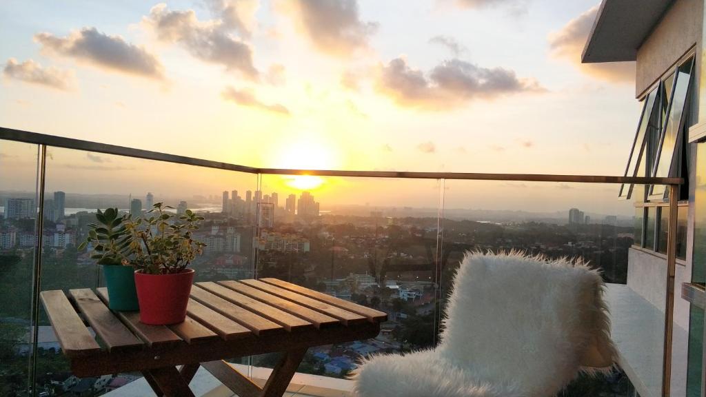 een balkon met een houten bank en een zonsondergang bij Ais-Kacang Sweet Home Pinnacle Tower in Johor Bahru