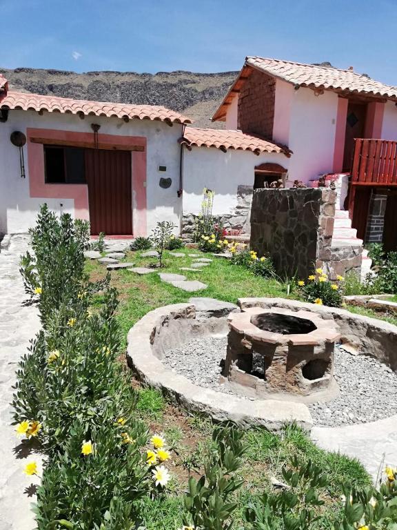 a garden with a fire pit in front of a house at Wayra Wasi in Coporaque