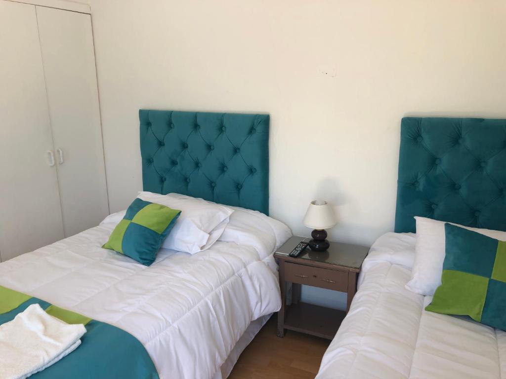 two beds sitting next to each other in a bedroom at Hotel Cecil in Vallenar