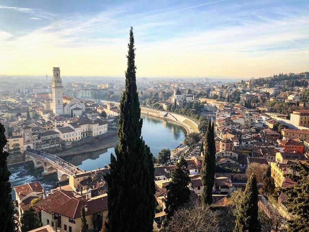 uitzicht op een stad met een rivier en een brug bij Musicisti House in Verona