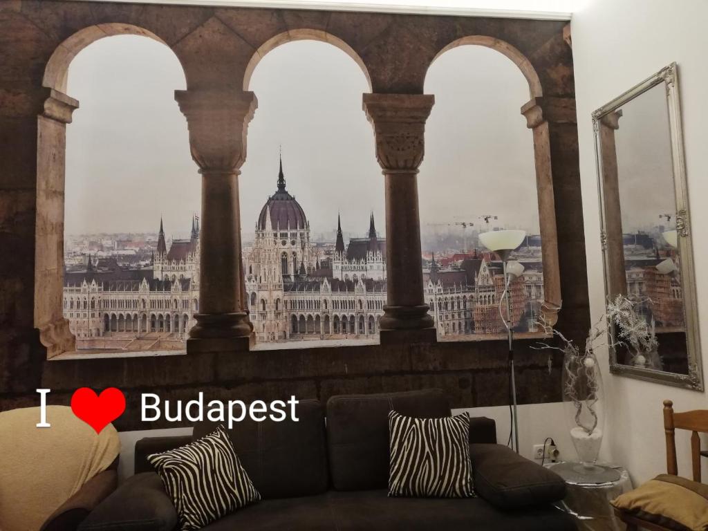 a living room with a couch in front of a window at West10 STAR City Center in Budapest