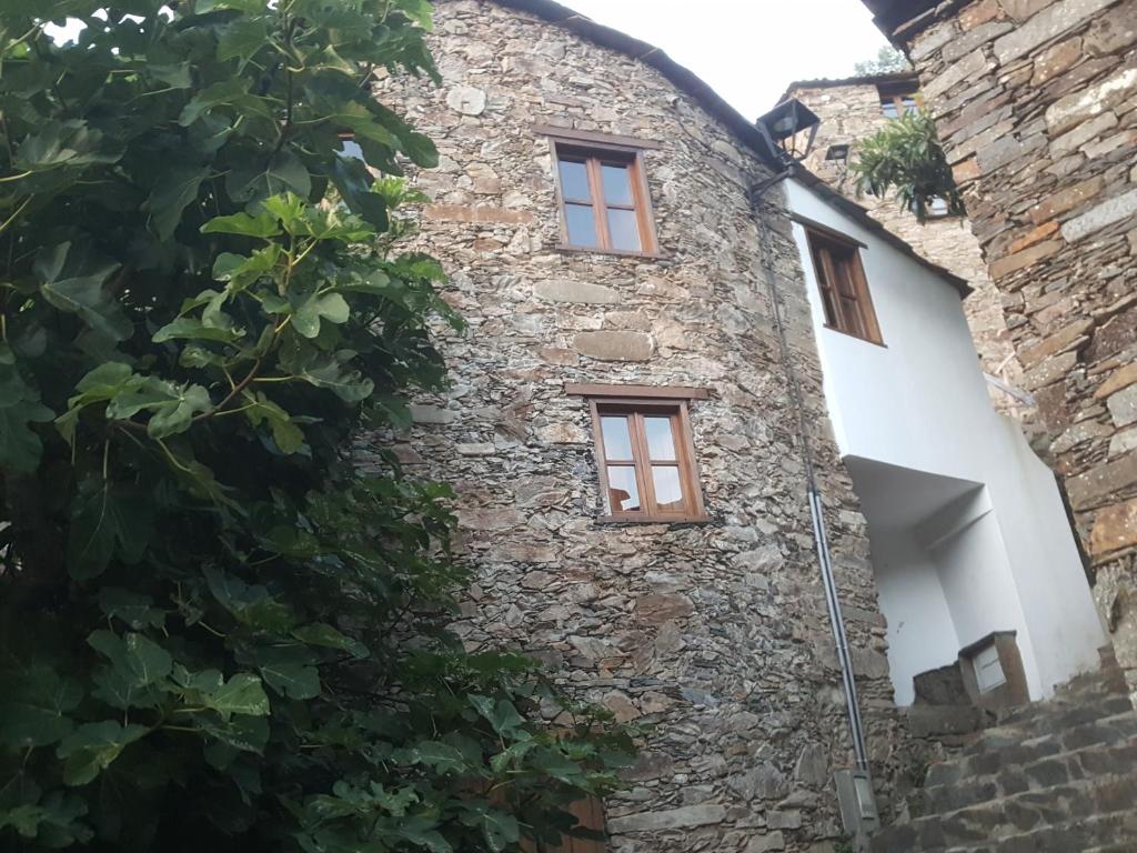 an old stone building with two windows on it at Casa da Carvalha in Lousã