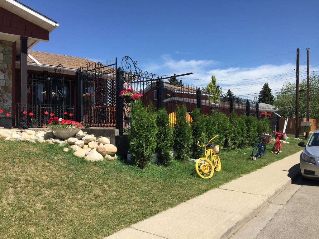 a yellow bike parked in the grass in front of a house at The Calgary Hub hostel style Home in Calgary