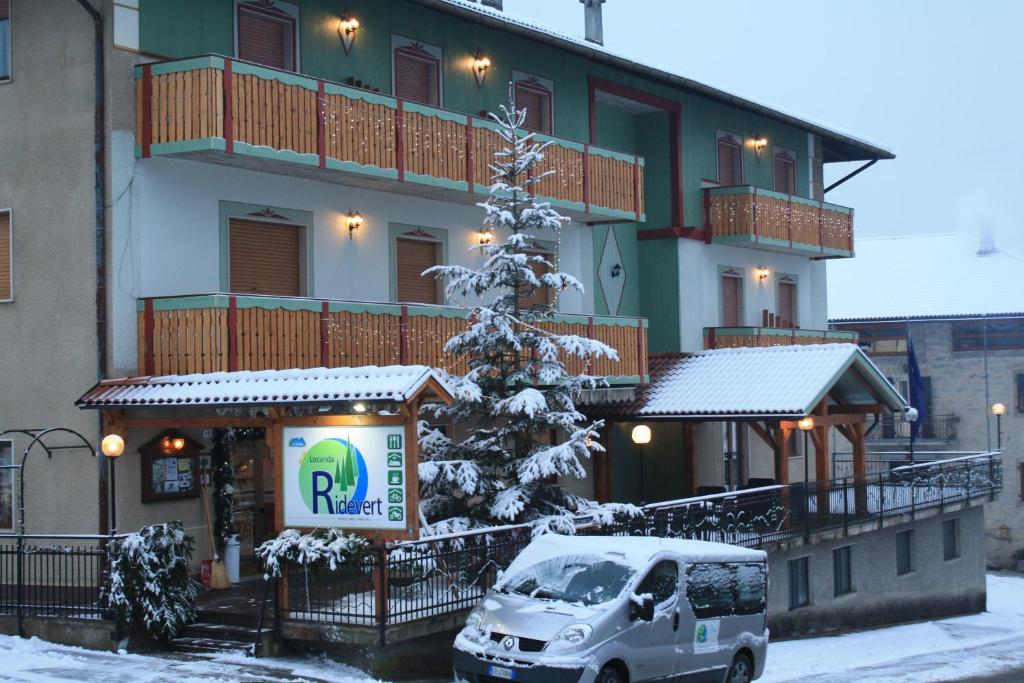 a van parked in front of a building with a christmas tree at Locanda Ridevert in Tione di Trento