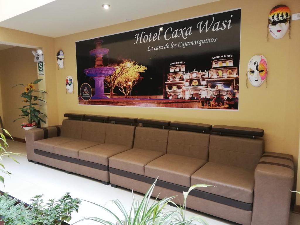 a couch in a waiting room with a sign on the wall at Hotel Caxa Wasi in Cajamarca