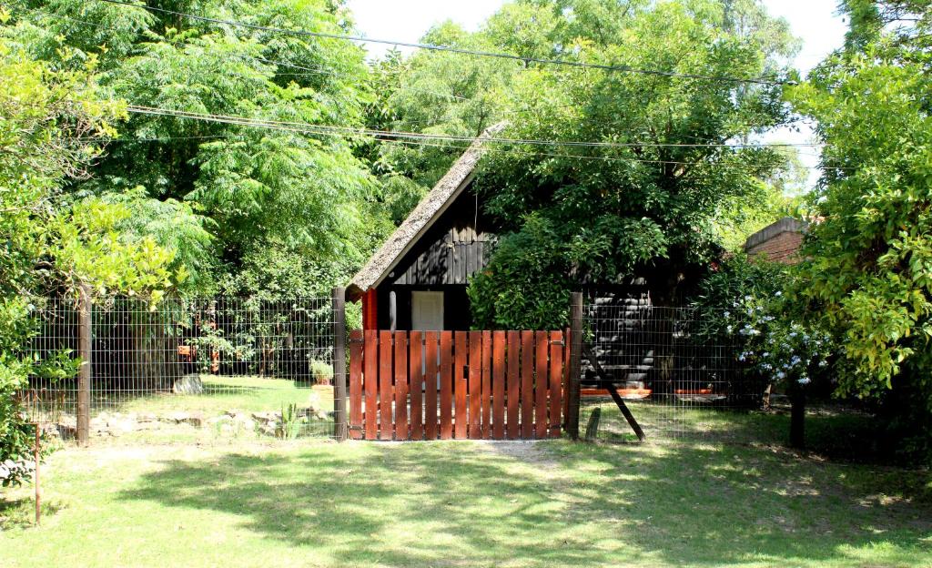 a smallshed with a wooden gate in a yard at LA CABAÑA in Atlántida