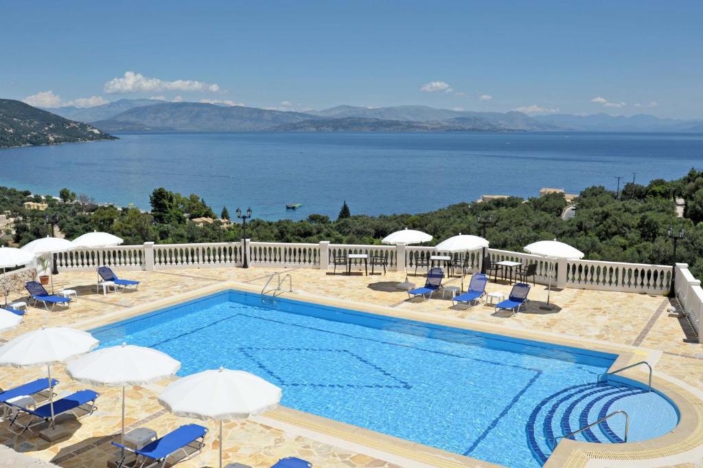 una piscina con sillas y vistas al agua en BBB - Barbati Blick Bungalows, en Barbati