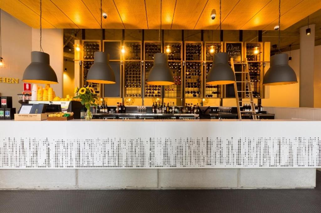 a bar with black pendant lights above a counter at Song Hotel Sydney in Sydney