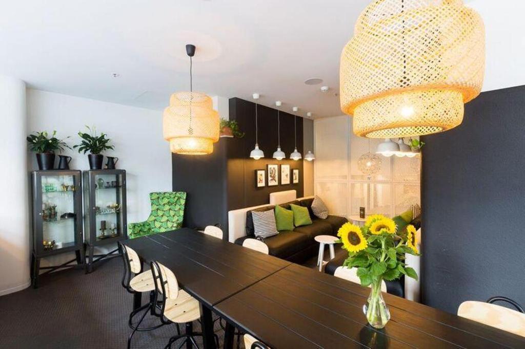 a dining room with a table and a living room at Song Hotel Sydney in Sydney