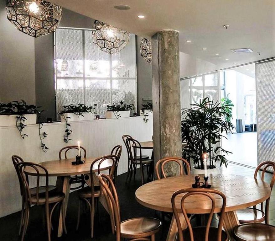 a restaurant with tables and chairs in a room at Song Hotel Sydney in Sydney