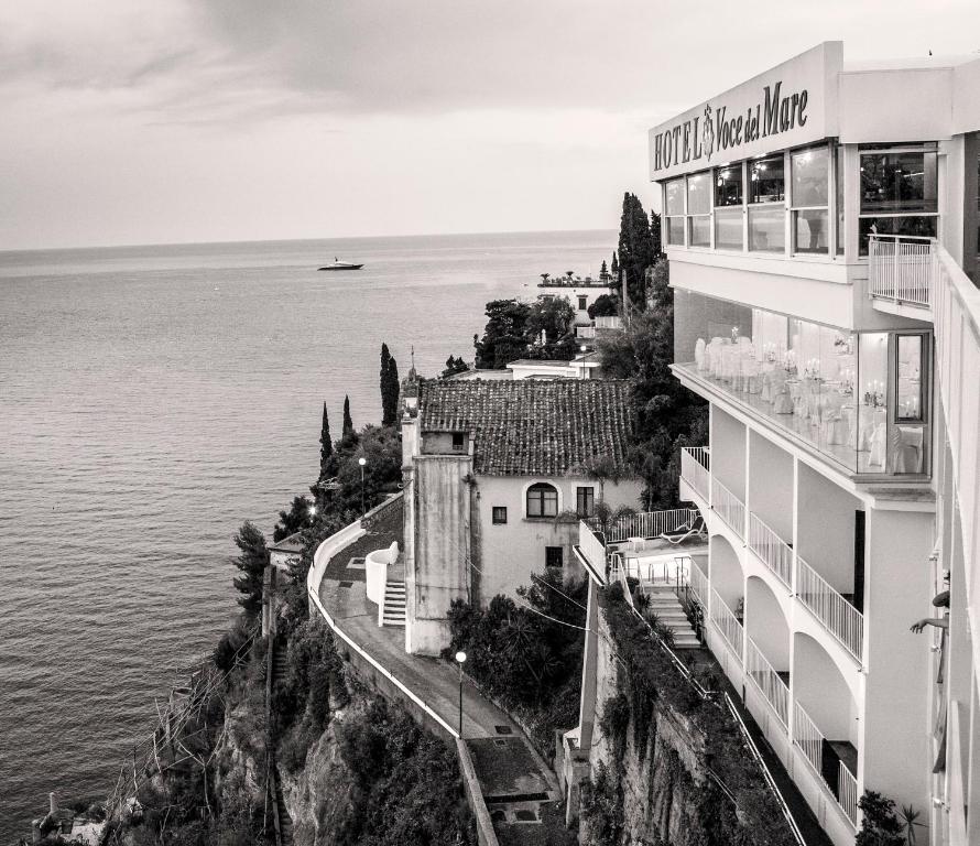 a black and white photo of a building next to the water at Hotel Voce del Mare in Vietri sul Mare