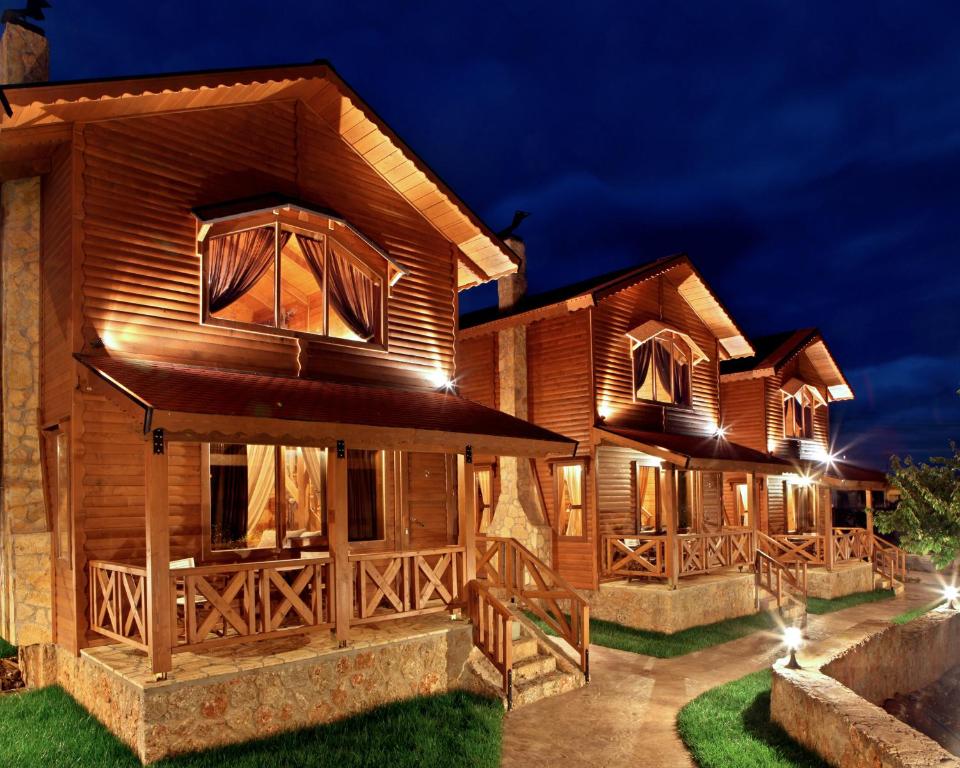 a wooden house with lights on it at night at Feggarognemata Suites in Ano Trikala