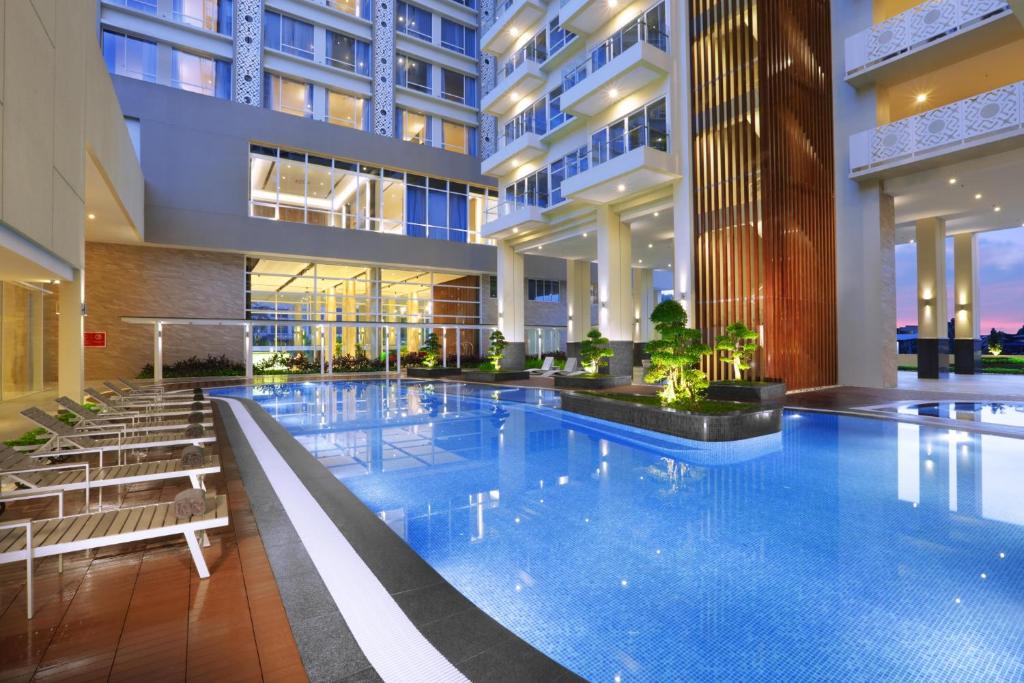 a large swimming pool in a building at ASTON Batam Hotel & Residence in Nagoya