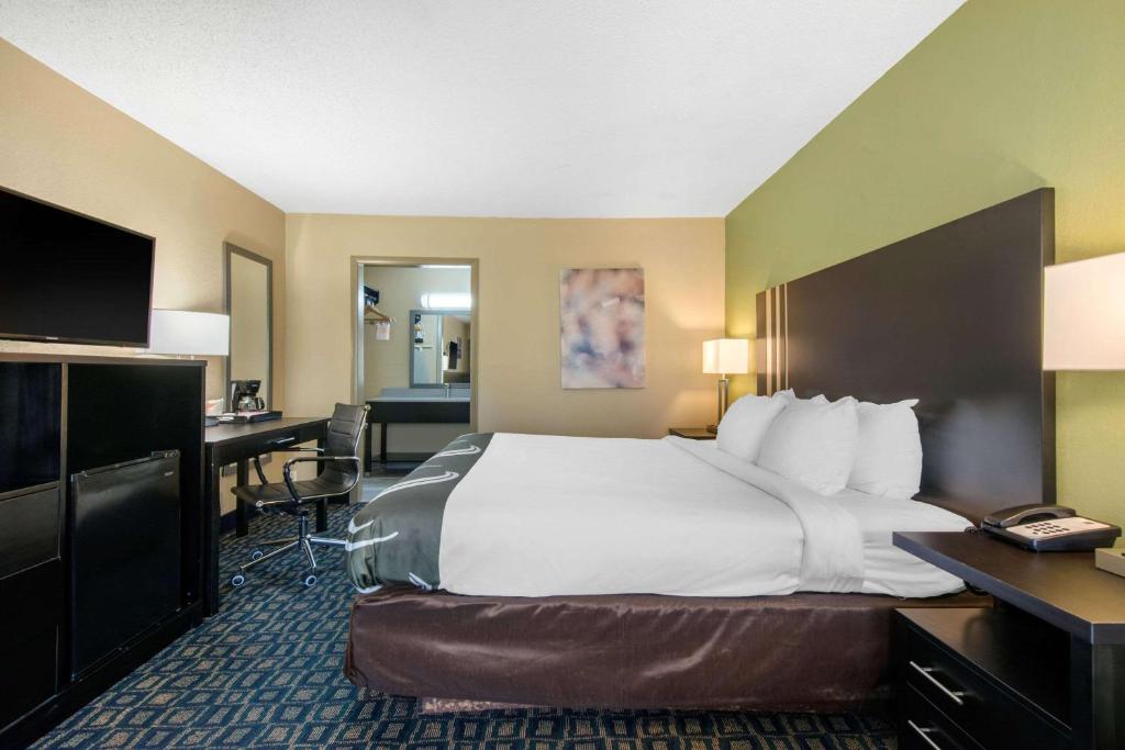 a hotel room with a large bed and a desk at Quality Inn & Suites Brooksville I-75-Dade City in Ridge Manor