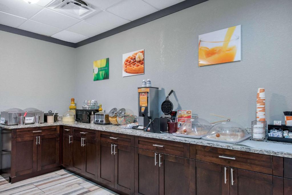 a kitchen with a counter top with wooden cabinets at Quality Inn & Suites Brooksville I-75-Dade City in Ridge Manor