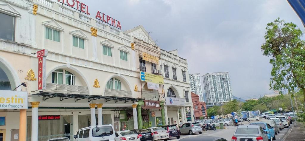 a busy street with cars parked in front of a building at Hotel Alpha in Bukit Mertajam