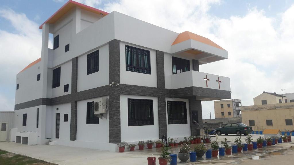 a white building with a cross on top of it at Meow Meow Fish B&B in Baisha