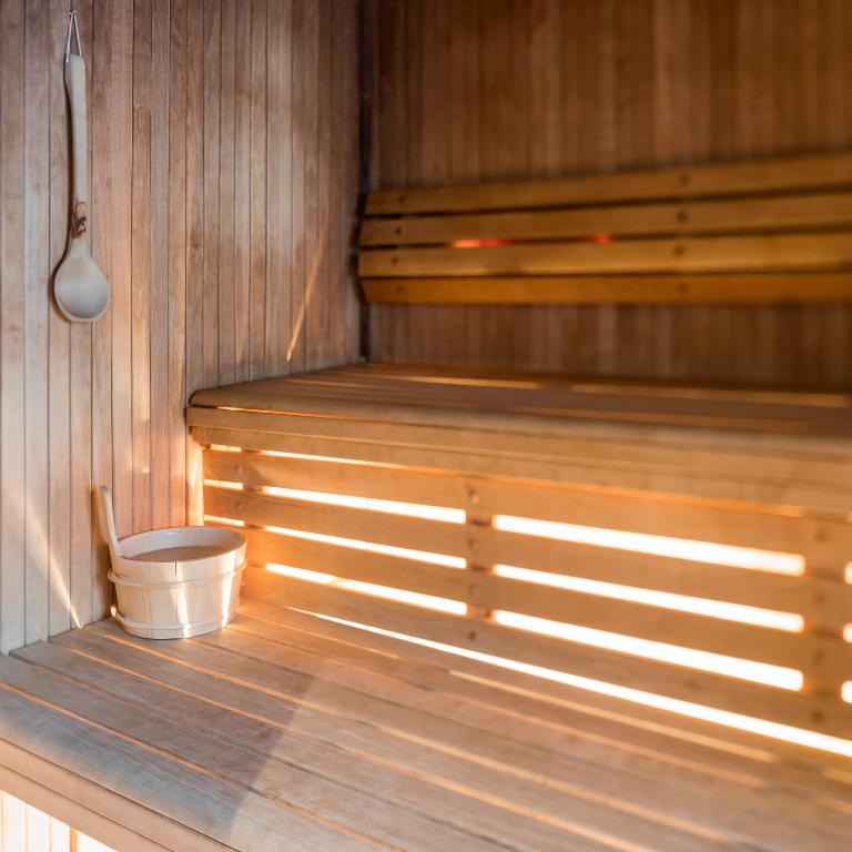 a sauna with a bucket on the floor of it at Hotel Montpelier in Verbier