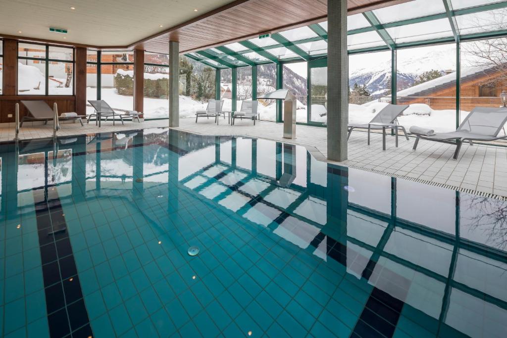 a swimming pool with a view of the mountains at Hotel Montpelier in Verbier