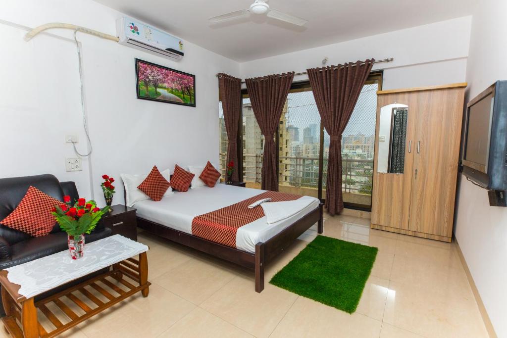 a bedroom with a bed and a couch and a tv at Aristo Hospitality Services Apartment, 1402,14th Floor in Mumbai