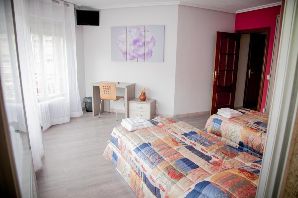 ein Schlafzimmer mit 2 Betten und einem Tisch darin in der Unterkunft Pensión Parque del Ebro in Logroño