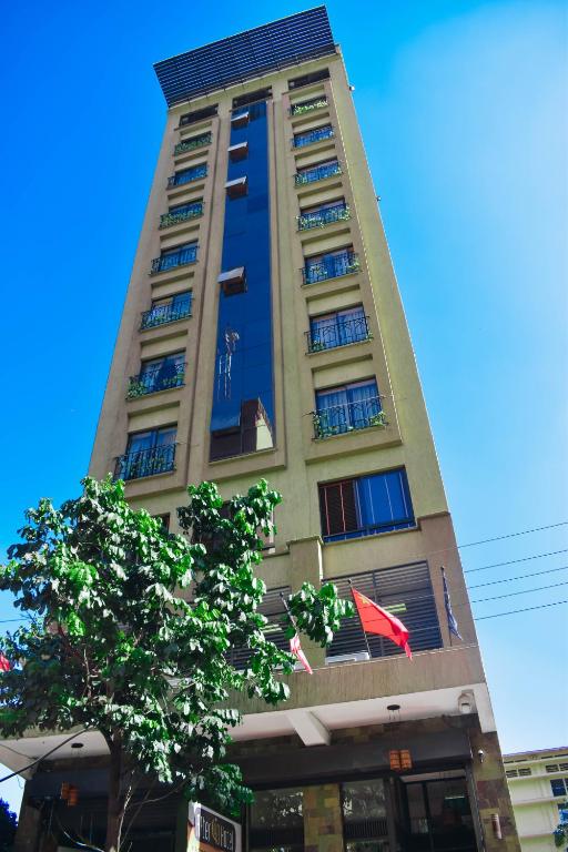 a tall building with a tree in front of it at After 40 Hotel in Nairobi
