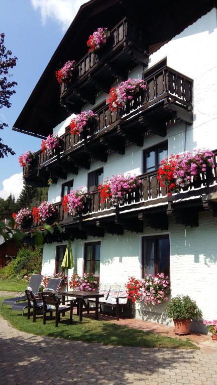 ein Gebäude mit Bänken und Blumen davor in der Unterkunft Ferienwohnung Leeb in Sirnitz