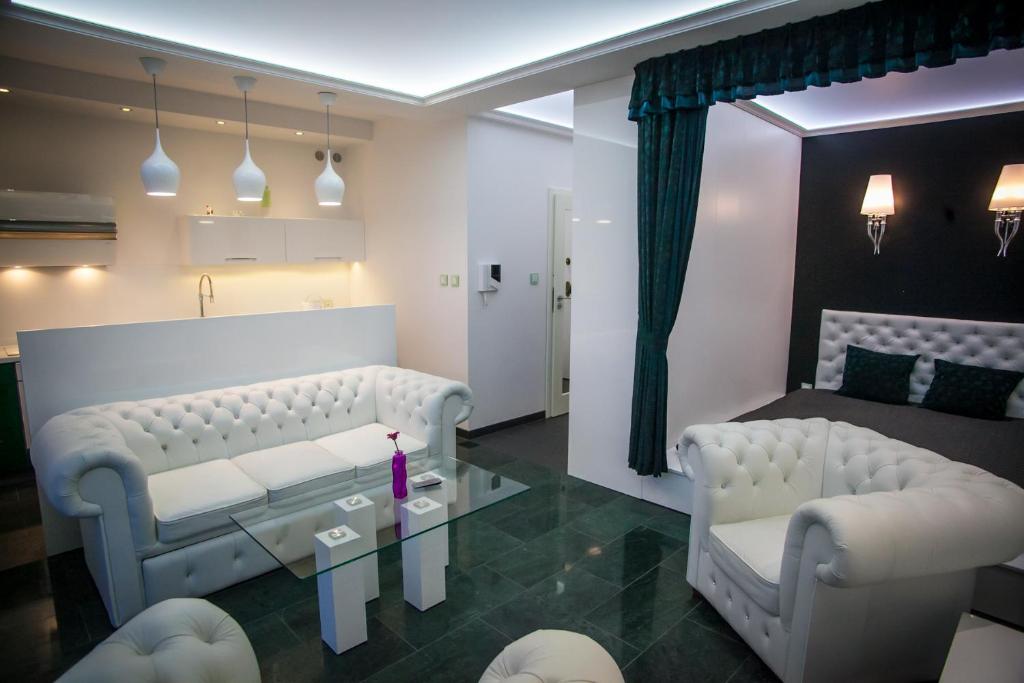 sala de estar con 2 sillas blancas y mesa en Royal Apartment in City Centre, en Suwałki