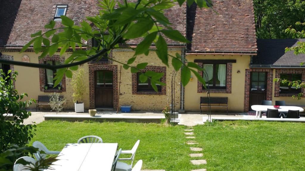 una casa con tavolo e sedie nel cortile di La Maison Lierue a Frétigny
