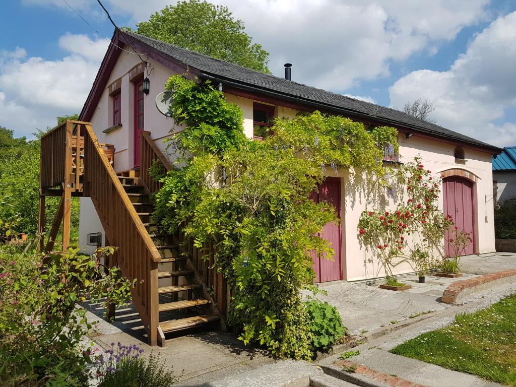 a small white house with a staircase leading up to it at Seren Loft - Cynghordy, Llandovery in Llandovery