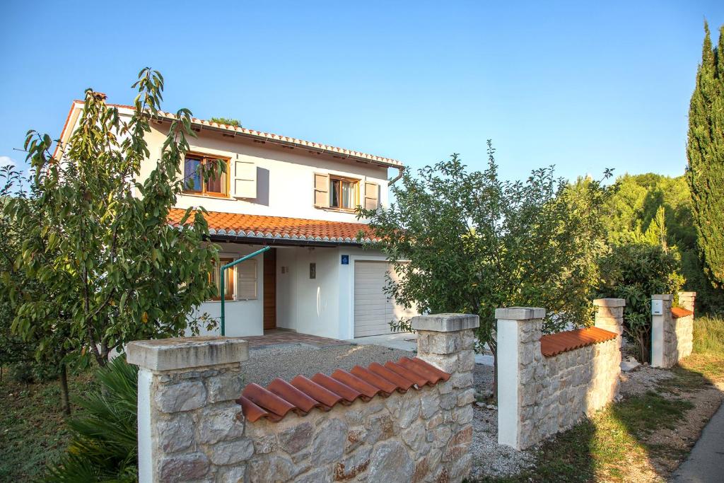 帕什曼的住宿－Holiday Home Magić，前面有石墙的房子