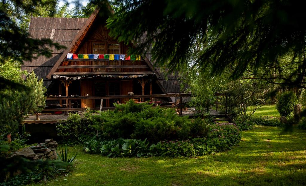 una cabaña de madera con banderas en la parte delantera en 'chata usÓwek', en Walim
