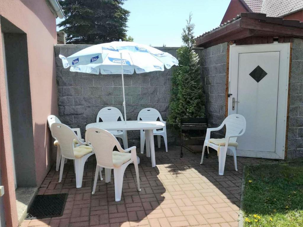 - une table, des chaises et un parasol sur la terrasse dans l'établissement Comfy Holiday Home near Forest in Medenec, à Měděnec