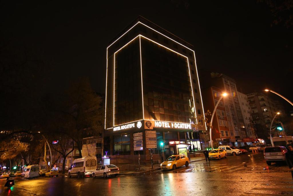 budynek z dużym budynkiem z samochodami zaparkowanymi na ulicy w obiekcie kocatepe hotel w mieście Ankara