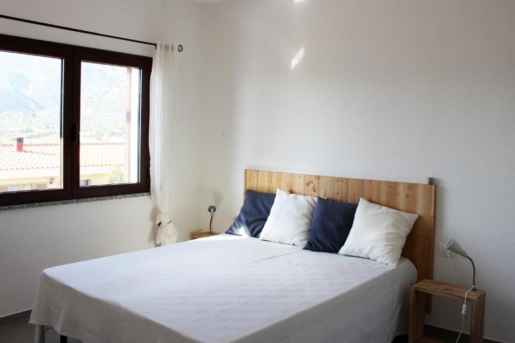 una camera con un letto bianco e una finestra di Residenze Branca I SeaView a Orosei