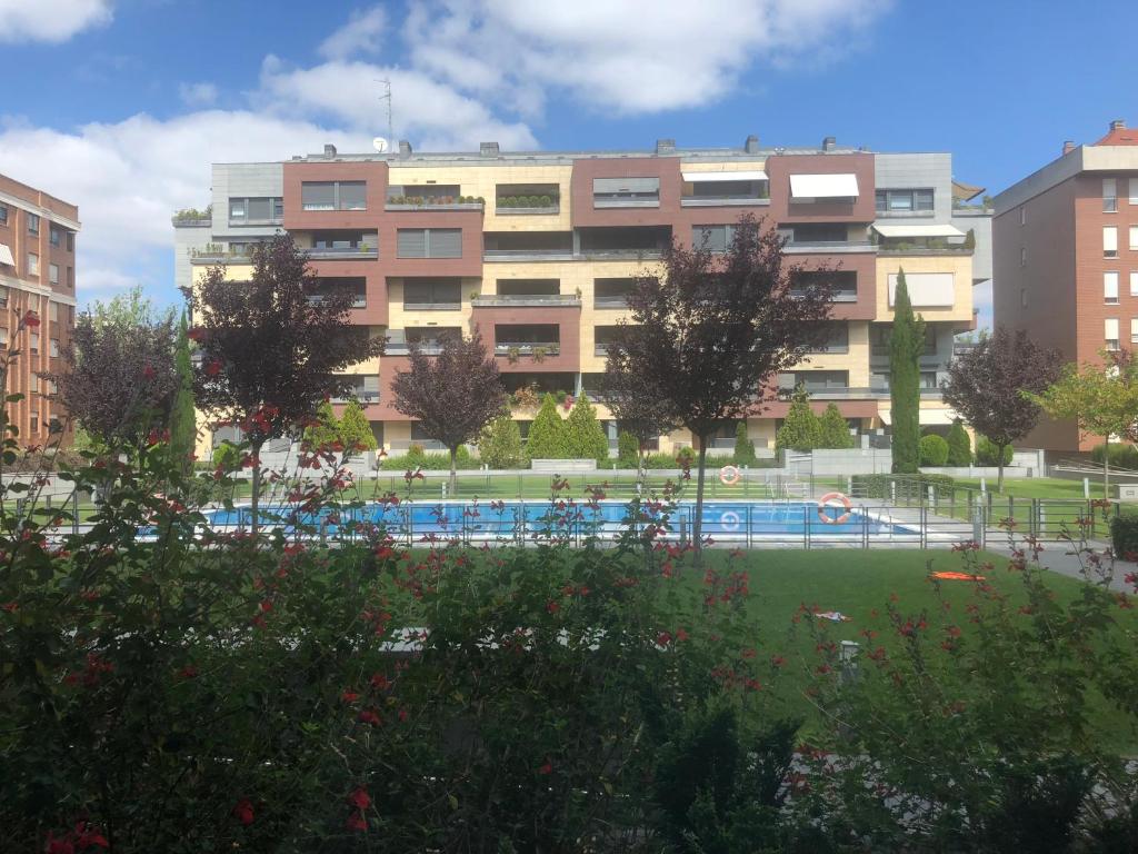 un gran edificio con una piscina en un parque en Apartamento Mercedes en Logroño