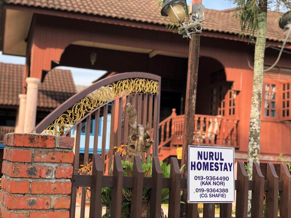 a sign on a gate in front of a house at Nuruls Homestay in Kuala Terengganu