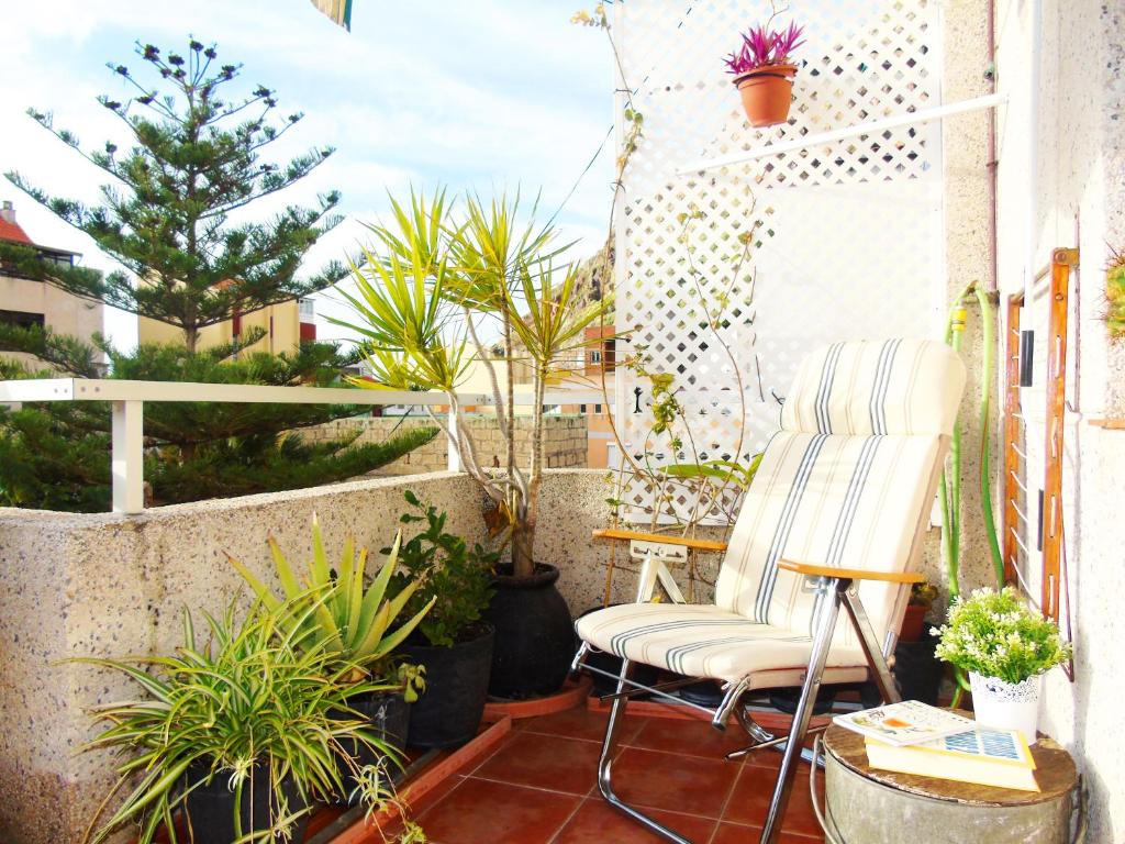 a chair sitting on a balcony with plants at Pepita Penthouse with Terrace & WiFi, close to the Teresitas Beach in San Andrés